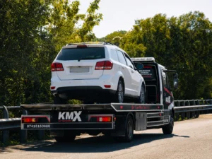 KMX recovery truck transporting a white SUV during a professional car recovery in Bury.